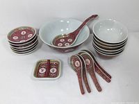 Complete set of bowls, spoons, and condiment dishes arranged showing quantity and pattern.