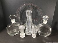 Photo of six crystal pieces including the Tiffany & Co. floral vine pattern cake plate at the back, two Luigi Bormioli whiskey decanters with faceted stoppers, Kaspar Bleikristall tall cut vase, and two small Fostoria bud vases in front.