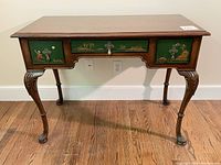 Full view of the antique desk showing the three drawers with green fronts and hand-painted Asian scenes, Queen Anne cabriole carved legs ending in claw feet.