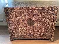 Front view of marbled buffet cabinet with decorative brass hardware