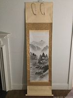 Full view of the Japanese hand-painted watercolor scroll hung on a wall, showing overall size and fabric mount with hanging loops.