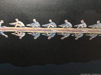 Close-up of the rowing crew in the print with reflections on water showing details of rowers and oars.