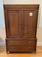 Front view of walnut-finish highboy cabinet
