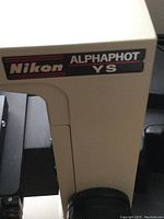 Close-up photo of Nikon Alphaphot YS logo on microscope body.