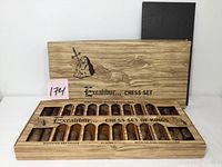 Open set packaging showing wooden styled compartments with chess pieces inside and Excalibur branding on box lid