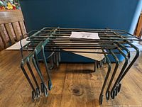 Five metal wire headstone saddles stacked showing rectangular frames and angled hooking ends