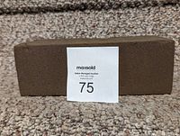 Rectangular dark brown floral foam brick placed on carpet background with auction lot tag labeled 75.