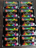 10 sealed packets of Mystical Fire color changing flame powder arranged in two columns of five on a surface.
