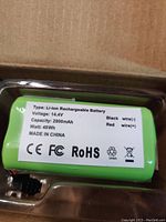 Close-up of the green cylindrical Keenstone rechargeable battery showing voltage 14.4V, capacity 2800mAh, wattage 40Wh, and wire color markings black and red. Certifications CE, FCC, RoHS shown.