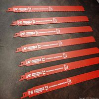 Seven red Diablo 12-inch automotive dismantling blades laid side by side showing length and condition.