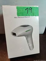 Photo of sealed box showing the device image and product name 'Hair Removal Device'.