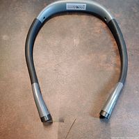 Full view of the LED neck light device showing its horseshoe shape with black and metallic silver colors.