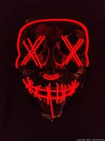 Red glowing LED light strips on mask forming two crossed Xs on eyes, nose, and stitched smile pattern, shown lit in dark.