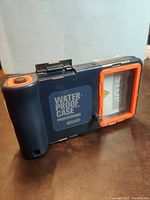 Front angled view showing waterproof case profile, orange accents, and viewing windows.