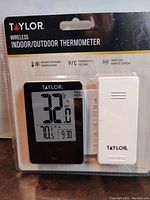 Sealed packaging showing Taylor wireless indoor/outdoor thermometer and white wireless remote sensor.
