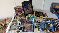 Full view of lot with Batcopter boxed, figures, magazines, cards and candy cars visible