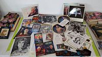 Wide view of Star Trek collectibles including photos, plates, lithograph, patches, and ephemera arranged on surface