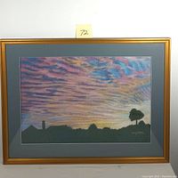 Front view of framed pastel artwork showing colorful sunrise sky with silhouetted trees and houses.