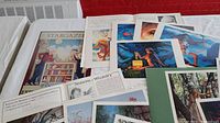 Overview of various signed and numbered art lithographs and portfolio prints spread on a table.