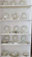 Full view of multiple plates, bowls, and teacups on shelves showing the breadth of the collection