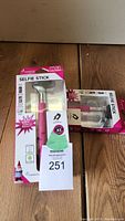 Pair of pink selfie sticks in original packaging showing front of boxes and branding.