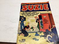 Front cover photo showing the comic book 'Suzie' Issue 91 from February 1953 with visible wear and torn spine.