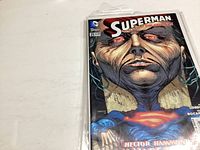 Front cover of a Superman comic showing a dark, ominous face with glowing eyes and the Superman emblem on chest, with issue number 21 seen.