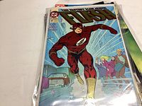 Photo of The Flash comic book with cover showing superhero running in red suit and yellow boots.