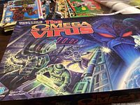 Closed box with colorful sci-fi themed art depicting astronauts and a robotic face, title: 'The Omega Virus'