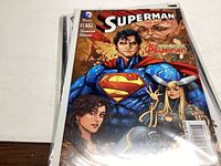 Photo showing Superman comic book with Superman and female character in blue and red costume