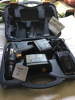 Black Mastercraft 24 volt cordless drill with battery pack and charger inside a black plastic carrying case.