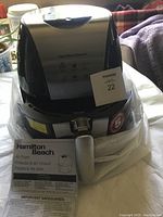 Hamilton Beach Digital Air Fryer with instruction manual placed in front, showing control panel and handle.