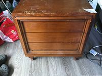 Front view of the antique wooden hall chest showing three drawers and some wear on the top surface.