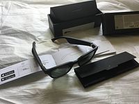 Black Bose Alto Style sunglasses laid flat with instruction sheets and open packaging
