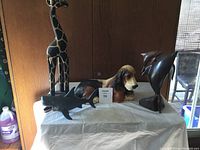 Front view showing giraffe, dog figurine, and wood dolphins on table.