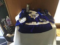Toronto Maple Leafs jersey displayed on a table, accompanied by a mini hockey stick and Bud Light headphones.