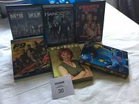 Seven DVD and Blu-ray cases displayed including Reba, The Simpsons, Men in Black, Hancock, Coyote Ugly, and F9.