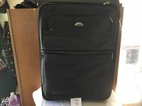 Front view of large black Sambor suitcase showing multiple zippered compartments and carry handle.
