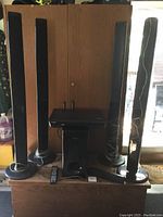 Full view of Samsung surround sound system with four standing speakers, subwoofer, and Blu-ray player on a wooden surface.