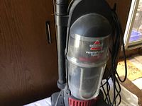 Front view of the vacuum cleaner showing the dust container and main body with Bissell PowerForce Turbo branding.