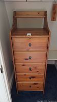Front view of the wood tower chest showing five drawers and open top shelf.