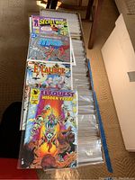 Open comic box showing top four issues: Secret Wars II, Teen Titans, Excalibur, Elfquest.