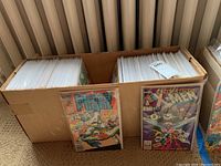Long cardboard box filled with two rows of bagged and boarded comics
