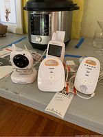 Photo of baby monitor devices including Levana camera and VTech monitors on a tabletop with background items.