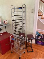 Photo showing the five items: tall black metal shoe rack, silver rolling shelf unit on wheels, two black metal C tables with wooden tops, and a smaller black metal rack.