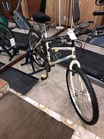 Side view of white Trek 830 mountain bike mounted on a blue stationary stand inside a fitness room.