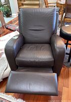 Front view of the Natuzzi Edition leather recliner with extended footrest, showing padded arms and cushioned seat and back.