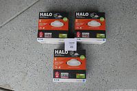 Three boxed HALO 6-inch LED recessed downlights stacked on the floor showing product packaging with branding and basic product info.