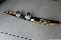 Photo of KD 7000 water ski showing attached double high-wrap boots, black ski with yellow and red stripes.