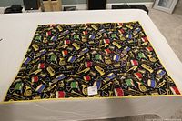 Full view of the quilt laid flat on a white surface showing the colorful musical instruments pattern and yellow border.